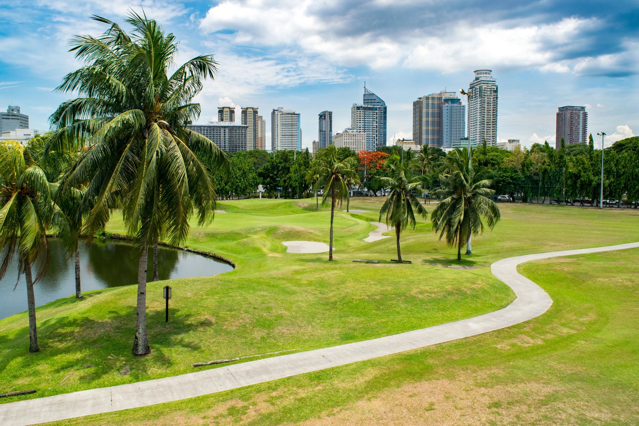 Manila skyline at sunset with a park in the foreground