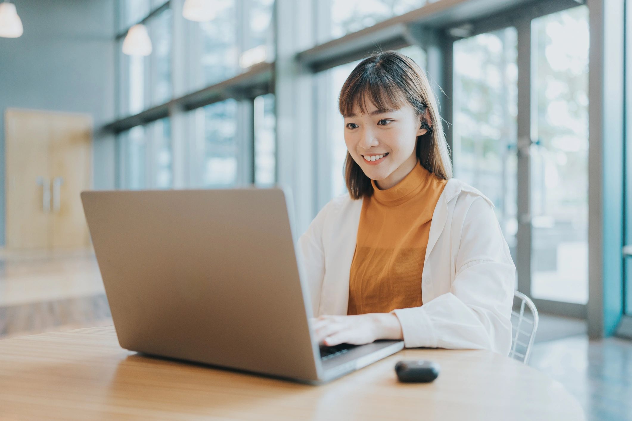 Person working on a laptop in a bright coworking space