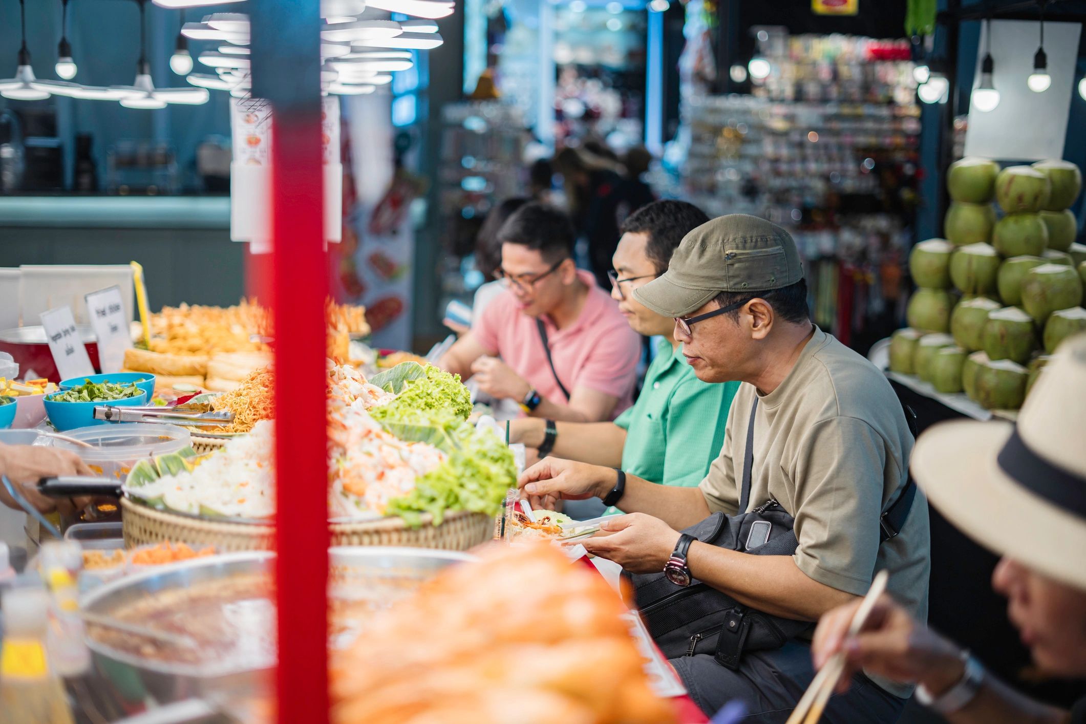 Traveler buying barbecue skewers from a street vendor in Bangkok at night