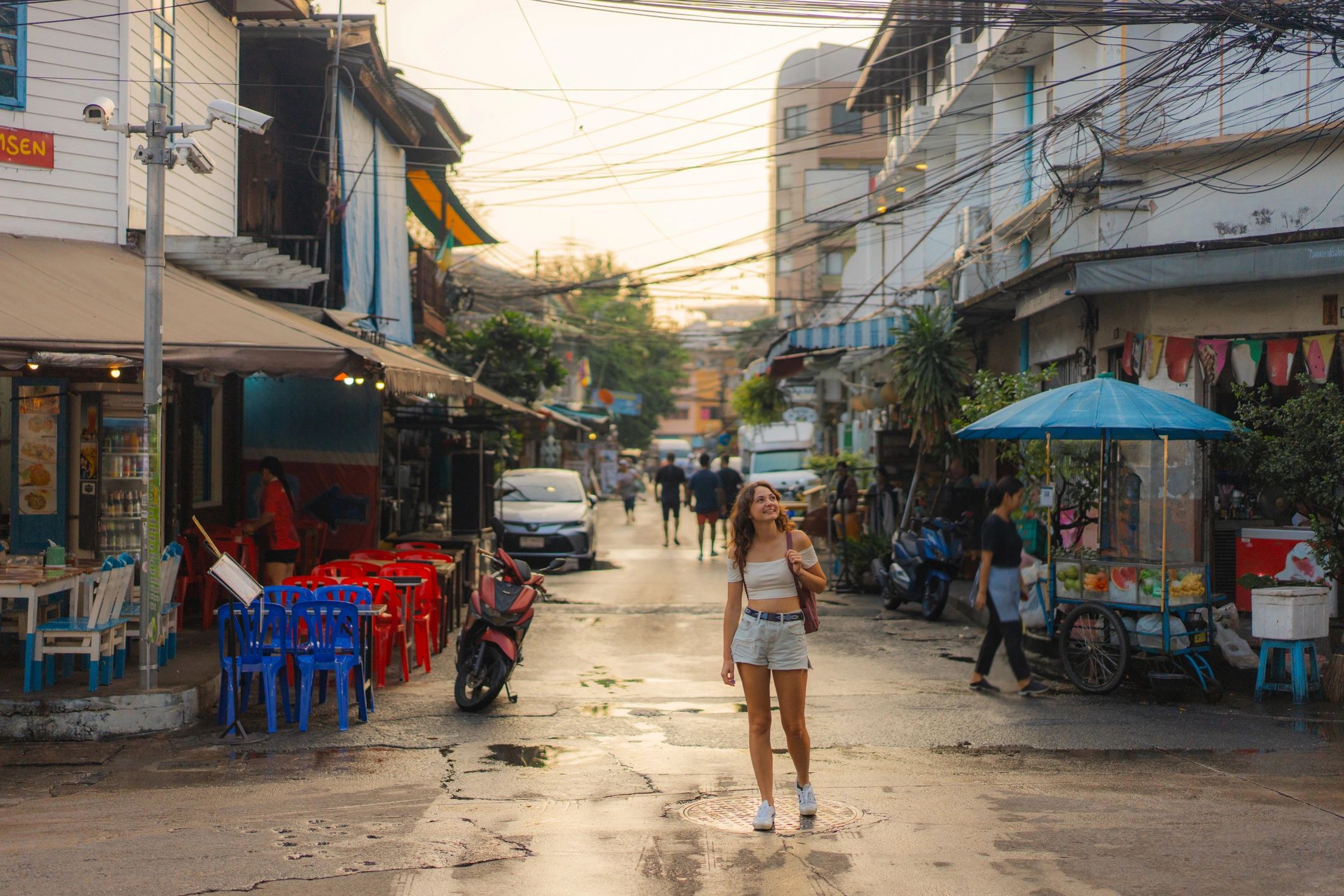 Person walking along a street in Bangkok at night