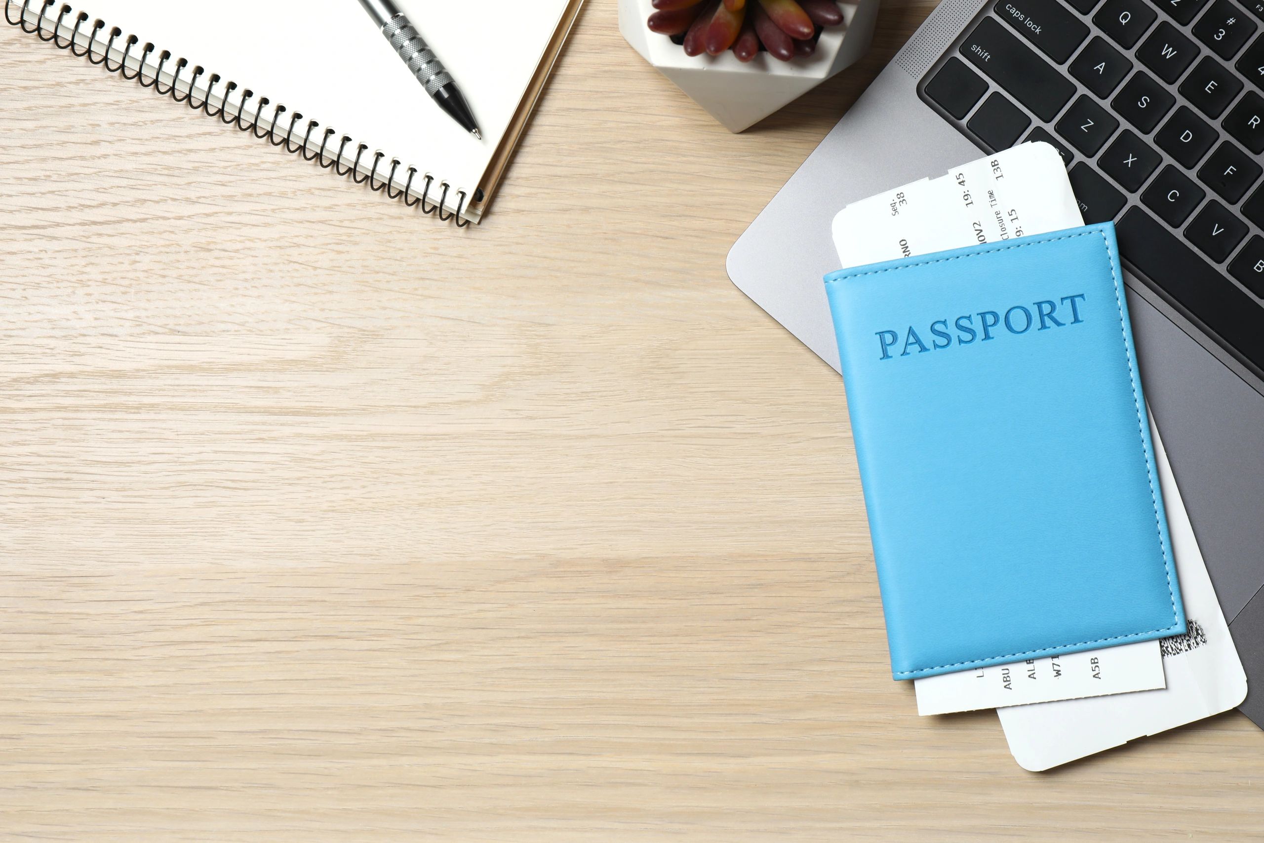 Passport, tickets, and laptop on a planning desk