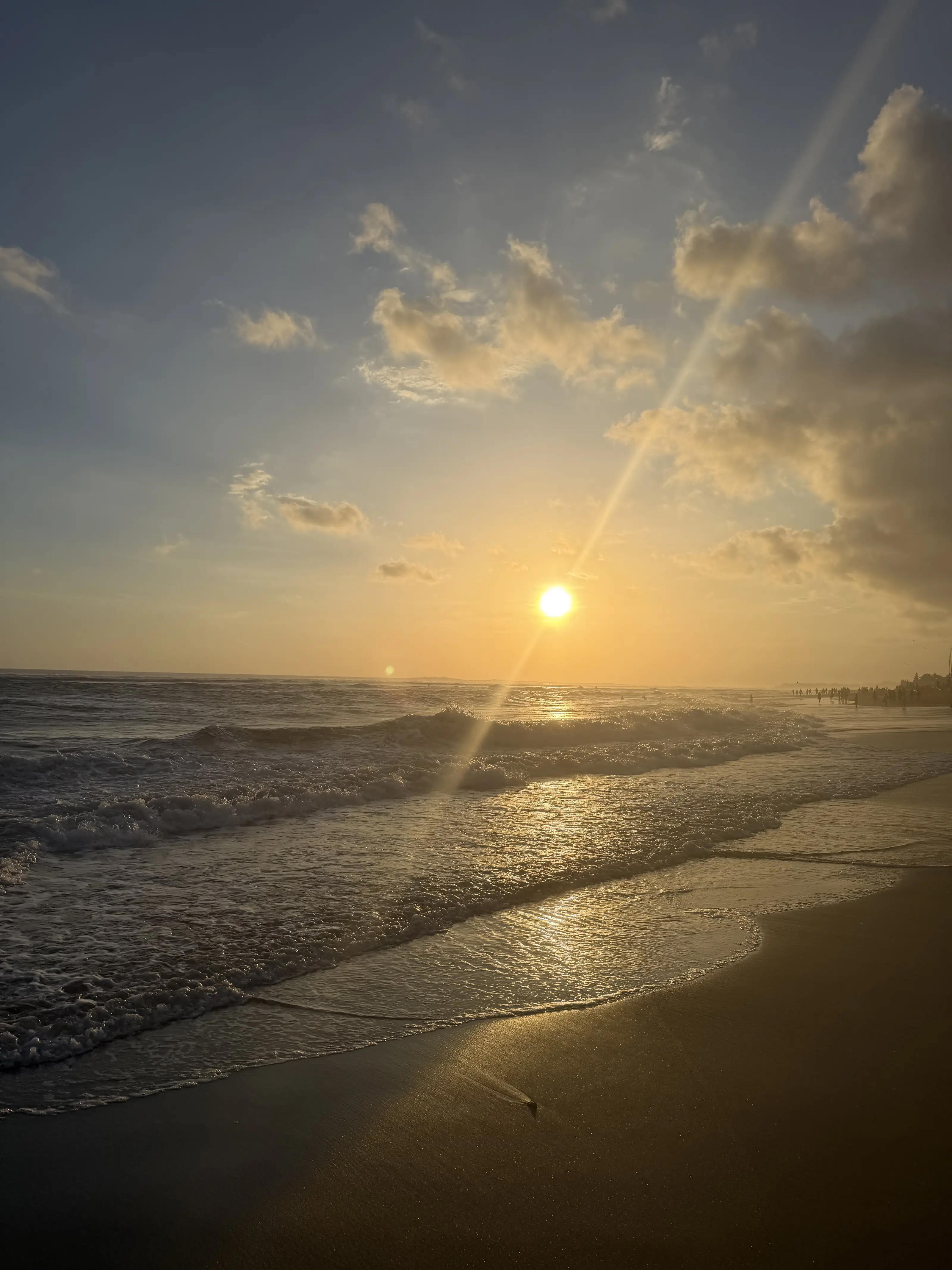 Sunlight over the waves and sand at Pantai Nelayan, Bali